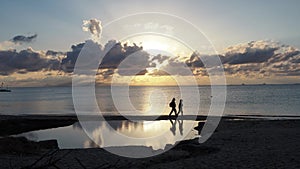 Beach-walking during a scenic dusk, with clouds reflecting at the sea and a coastal pond in Greece