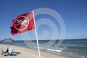 Beach Warning Flag the No Swimming Flag, riptide. clear sky summer beach day. Ocean waters photo