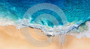 Beach and waves as a background from top view. Blue water background from drone. Summer seascape from air.