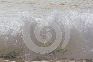 Beach waves crash towards the shore on a hot summer morning