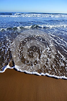 Beach with waves reaching mediterranean shore