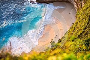 Beach and waves. Vacation and adventure. Top view from rocks on the beach and blue sea. Indonesian landscape.