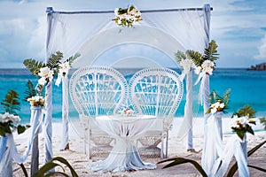 Beach wedding arch gazebo ceremonial decorated with white flowers on a tropical grand anse sand beach. Outdoor beach