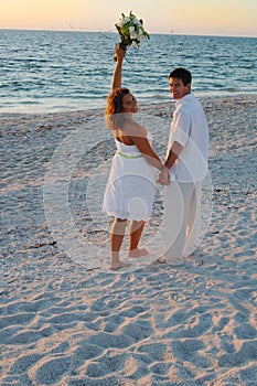 Beach wedding couple celebrate