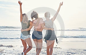 At the beach is where youll find us. three friends spending the day at the beach.