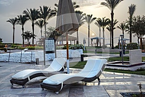 Beach white sun loungers with umbrella