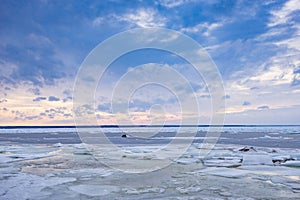 Beach in wintertime. Frozen sea, evening light and icy weather on shore like fairy tale country.