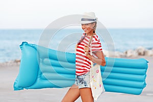 Spiaggia una donna Contento un logorante Spiaggia un cappello blu materassi con estate divertimento durante viaggio vacanza vacanza 