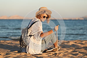 Beach woman happy and wearing sunglasses and beach hat having summer fun during travel holidays vacation