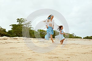 Beach. Woman And Kid Walking On Ocean Coast. Young Mother In Fashion Maxi Dress With Daughter At Tropical Resort.