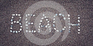 'Beach' word on the sand. Written with pebbles. Aged photo.