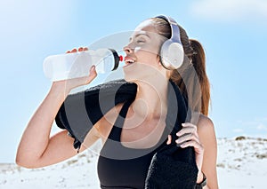 Beach, workout and drinking water with headphones music for exercise, fitness and training break. Wellness, relax and