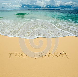 The beach written in a sandy tropical beach