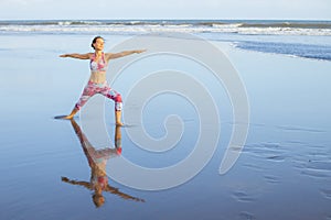 Beach yoga. Caucasian woman practicing Virabhadrasana II, Warrior II Pose. Strong body. Healthy lifestyle. Water reflection. Yoga