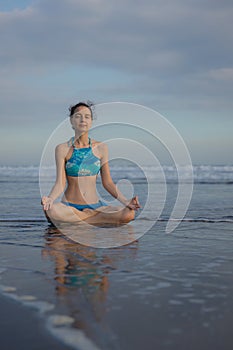 Beach yoga practice in Bali. Lotus pose. Padmasana. Hands in gyan mudra. Meditation and concentration. Zen life. Relaxation of