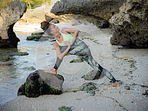 Beach yoga practice. Parivrtta Anjaneyasana  Twisted High Lunge Pose. Slim Caucasian woman practicing yoga on the beach.