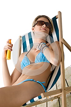 Beach - Young woman apply suntan lotion