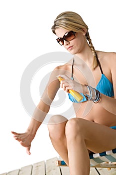 Beach - Young woman in bikini apply suntan lotion