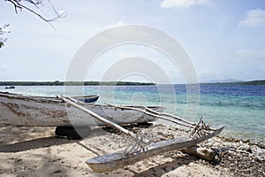 Beached indiginous canoe next to the ocean photo