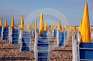 beaches with umbrellas closed and deck chairs closed at the end photo