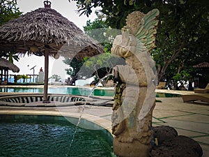Beachfront Swimming Pool Garden View With Fountain Balinese Ethnic Statue Of The Resort At Pemuteran Village photo