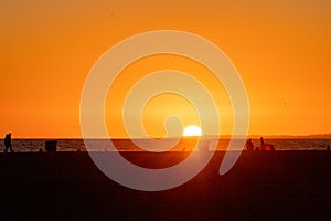 Beachgoers, families the sunset and the Santa Monica Pier