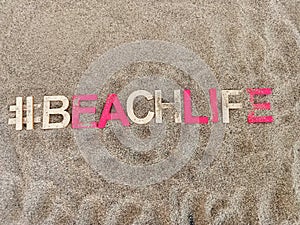 #beachlife beach life written on sand at the beach photo
