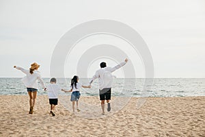 Beachside joy as parents hold hands run and jump with their children in holiday