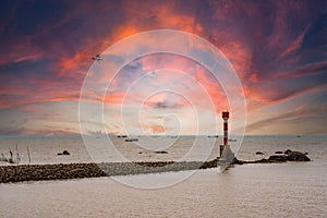 The beacon lighthouse under the gorgeous sunset by the sea