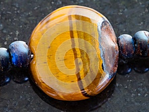 bead from Tiger's eye gemstone on dark