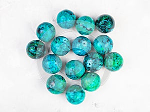 Beads from natural Chrysocolla gemstone on gray