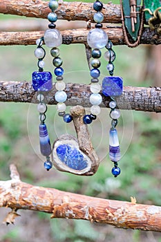 Beads and pendants made from metal and natural minerals on wooden background. Handcraft precious item. Jewelry accessories