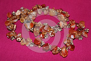 Beads from semiprecious stones on a pink background. Beads close up. Women`s jewelry