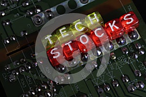 Beads Spelling `Tech Stocks` With PCB In The Background