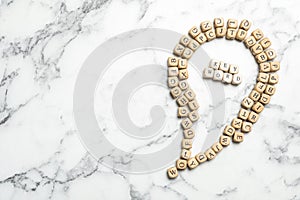 Beads with word KEYWORD on marble background, flat lay. Space for text