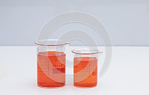 Beaker with color liquid. Solution chemistry. Laboratory beaker with colored liquid over white background