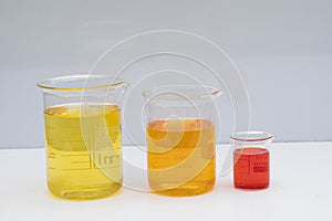 Beaker with color liquid. Solution chemistry. Laboratory beaker with colored liquid over white background