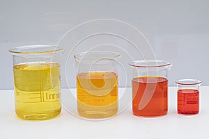 Beaker with color liquid. Solution chemistry. Laboratory beaker with colored liquid over white background