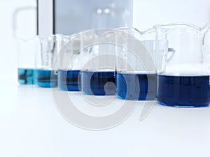 The beakers with color range  solution on bench laboratory, with stannous chloride solvent for analysis phosphate experiment.