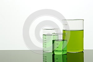 Beakers of different size with green liquid. Copy space.