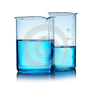 Beakers with liquid on table against color background