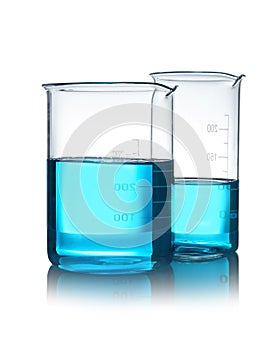 Beakers with liquid on table against white background