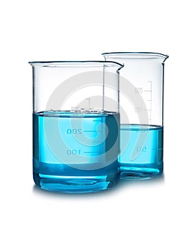 Beakers with liquid on table against white background.