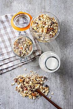 Beakfast cereals in bowl and milk in bottle. Healthy muesli with oat flakes, nuts and raisins
