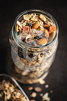 Beakfast cereals in jar. Healthy muesli with oat flakes, nuts and raisins