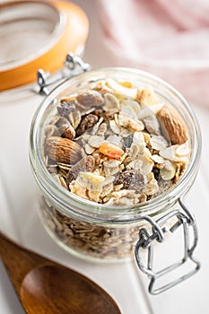 Beakfast cereals in jar. Healthy muesli with oat flakes, nuts and raisins