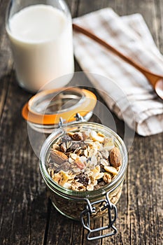 Beakfast cereals in jar. Healthy muesli with oat flakes, nuts and raisins