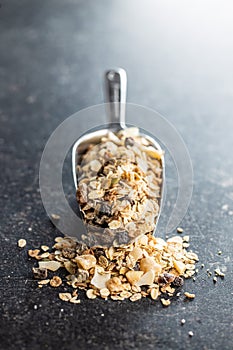 Beakfast cereals in scoop. Healthy muesli with oat flakes, nuts and raisins