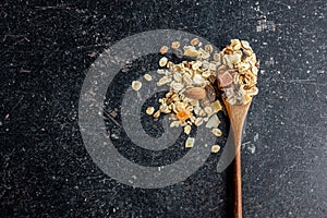 Beakfast cereals in wooden spoon. Healthy muesli with oat flakes, nuts and raisins