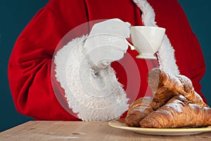 Beakfast of Santa Claus. Santa drinking coffee and eating croissants. Close-up view